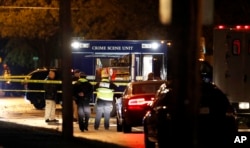 Law enforcement officials investigate at the scene of a shooting, Nov. 2, 2016, in Urbandale, Iowa.