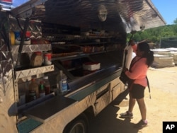 FILE - Nancy Vasquez, a Salvadoran citizen in the U.S. with a Temporary Protected Status (TPS), cleans her food truck at a construction site in Rockville, Maryland.