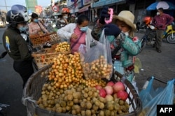 រូបឯកសារ៖ អាជីវករកំពុងថ្លឹងផ្លែឈើ នៅតាមដងផ្លូវ នៅរាជធានីភ្នំពេញ កាលពីថ្ងៃទី ១១ ខែឧសភា ឆ្នាំ ២០២១។
