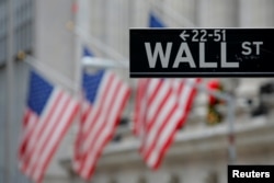 FILE - A street sign for Wall Street is seen outside the New York Stock Exchange (NYSE) in Manhattan, New York City, Dec. 28, 2016.