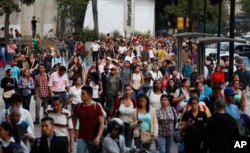 People spill into an avenue after a power outage in Caracas, Venezuela, March 7, 2019. A power outage left much of Venezuela in the dark Thursday evening in what appeared to be one of the largest blackouts in a country where power failures have become common.