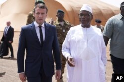 Le président français Emmanuel Macron, à gauche, s'entretient avec le président malien Ibrahim Boubacar Keita alors qu'ils rencontrent des soldats français de l'opération Barkhane, la plus grande opération militaire française, dans le nord du Mali, le 19 mai 2017.