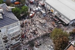 Gambar dari drone menunjukkan orang-orang melakukan pencarian korban di sebuah bangunan yang runtuh setelah gempa bumi yang kuat melanda Laut Aegea yang meruntuhkan sejumlah bangunan di provinsi pesisir Izmir, Turki, 30 Oktober 2020.