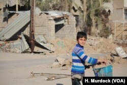 Children play among houses destroyed by car bombs while airstrikes and gunfire are heard in other neighborhoods in Mosul, Jan. 11, 2017.