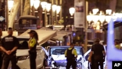 Des policiers déployés près d’une camionnette utilisée lors d’une attaque contre des passants sur l'allée centrale des Ramblas, au cœur touristique de la capitale catalane, 17 août 2017.