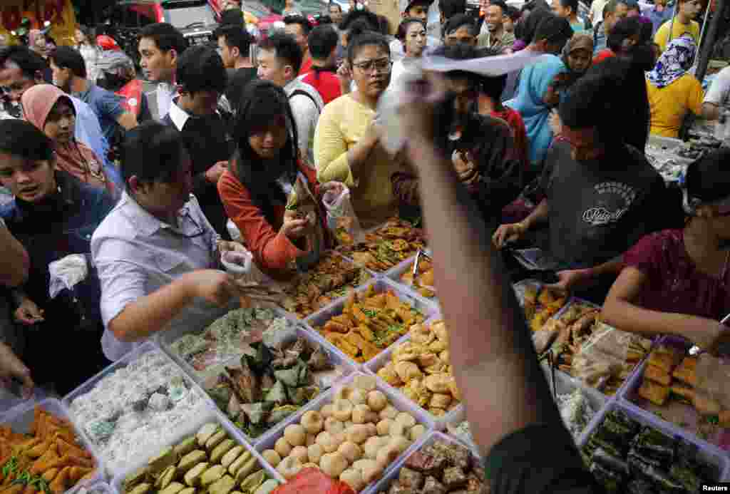A street vendor sells food for iftar, the meal that breaks the fast at sunset, at Benhill food market during the holy month of Ramadan, Jakarta, June 30, 2014.
