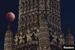 A "super blood blue moon" is seen during an eclipse at a temple in Bangkok, Thailand, Jan. 31, 2018.