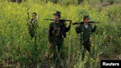 FILE - Rebel soldiers of Myanmar National Democratic Alliance Army (MNDAA) patrol near a military base in Kokang region, March 10, 2015. 