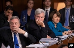 Democrats on the Senate Judiciary Committee, from left, Sen. Dick Durbin, D-Ill., Sen. Sheldon Whitehouse, D-R.I., and Sen. Amy Klobuchar, D-Minn., and other minority members, appeal to Chairman Chuck Grassley, R-Iowa, to delay the confirmation hearing of Brett Kavanaugh.