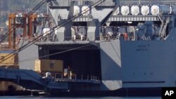 FILE - A truck carrying a container from the Danish vessel Ark Futura drives into the hold of the U.S.-owned MV Cape Ray, at Gioia Tauro port, southern Italy, July 2, 2014.