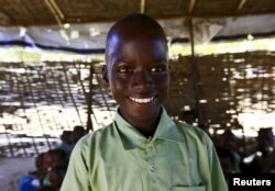 Mohamed Ali Ishag, a 4th grader at the Ardamata camp for the internally displaced poses for a photograph in El-Geneina in West Darfur, Sudan, Nov. 24, 2015.