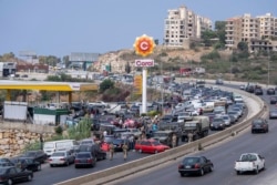 Cars come from every direction to fill their tanks with gasoline at a petrol station on the main highway in the coastal town of Jiyeh, south of Beirut, Lebanon, Sept. 3, 2021.