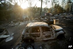 A vehicle scorched by a wildfire rests in a clearing on Wolf Creek Road near Clearlake Oaks, California, June 24, 2018.