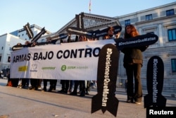 People hold placards reading "Decisions that kill" during a gathering to demand a halt of arms sales to Saudi Arabia, outside Parliament in Madrid, Spain, Oct. 24, 2018.