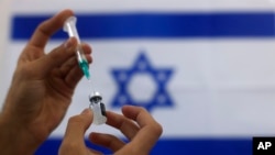Seorang paramedis militer Israel menyiapkan vaksin Pfizer COVID-19, untuk diberikan kepada orang lanjut usia di pusat medis di Ashdod, Israel selatan, Kamis, 7 Januari 2021. (Foto: AP/Tsafrir Abayov)