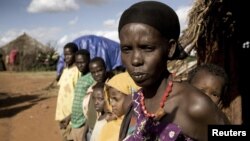 FILE - A women and her children stand next to their house on the outskirts of Moyale, Ethiopia, a nation where not many books are written in local languages, and few Ethiopians read for pleasure.