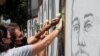 People put white roses on portraits of victims of last year's Beirut port blast as Lebanon marks one year anniversary of the explosion, in Beirut, Lebanon, Aug. 3, 2021.