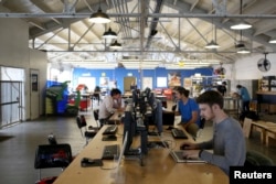 FILE - Designers work at computer stations at TechShop in the South of Market neighborhood in San Francisco, Calif., April 24, 2014. Silicon Valley got its start from hardscrabble tinkerers building radios, microchips and other devices, but a proliferation of high-tech but affordable manufacturing tools and new sources of funding are empowering a generation of handy entrepreneurs.