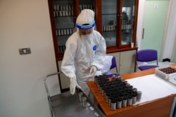 Seorang petugas kesehatan mengumpulkan sampel yang diperiksa oleh anjing yang telah dilatih untuk mengendus virus COVID-19 di Universitas Chulalongkorn, di Bangkok, Thailand 21 Mei 2021. (REUTERS / Jorge Silva)