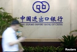 FILE - A man walks past the lobby of the Export-Import Bank of China (EXIM) headquarters in Beijing, June 13, 2017. “ExIm has become more risk-averse for new projects,” said Yunnan Chen, a researcher at the China Africa Research Initiative at SAIS.