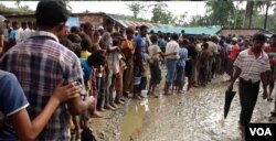Rohingya refugees line up for water at a new settlement near Uchi Prank, Bangladesh.
