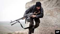 FILE - Free Syrian Army fighter takes cover during fighting in Azaz.