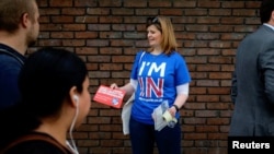 FILE - A woman campaigns in London, May 20, 2016, for Britain to stay in the European Union.