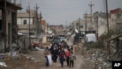 A Palestinian man rides a donkey-drawn cart transporting an old car to a scrap yard, in Gaza City.