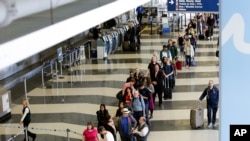Des voyageurs attendent dans la file de sécurité, à l'aéroport de Chicago, le 16 mai 2016.