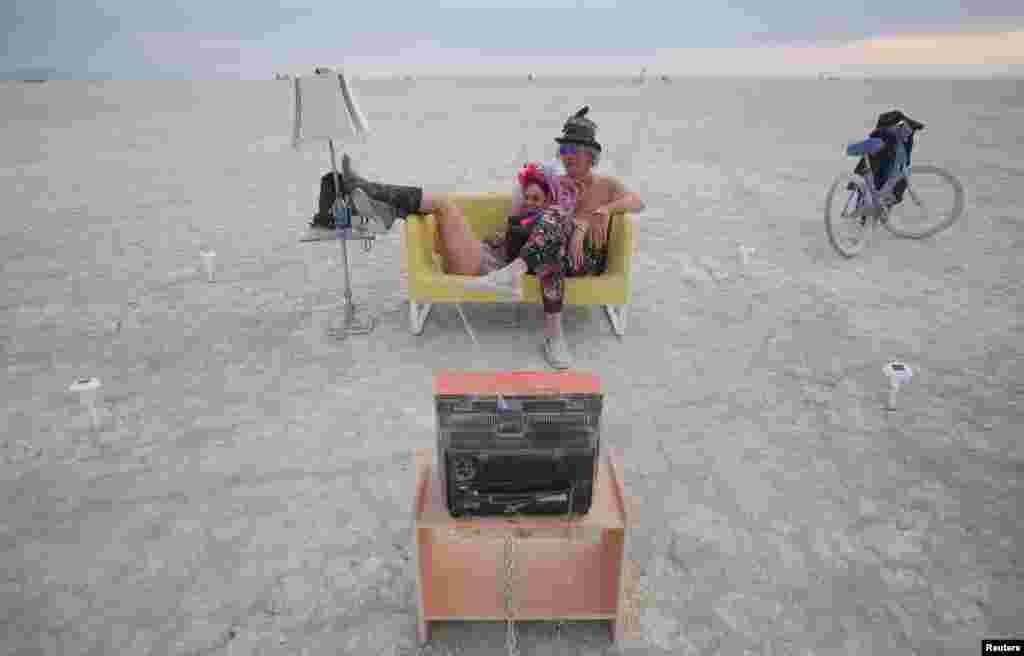 Jody Friedman and Jeff Montgomery sit in front of the Playa TV as approximately 70,000 people from all over the world gather for the 30th annual Burning Man arts and music festival in the Black Rock Desert of Nevada, USA, Aug. 30, 2016.