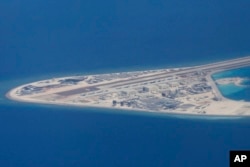 FILE - An airstrip and buildings on China's man-made Subi Reef in the Spratly chain of islands in the South China Sea are seen from a Philippine Air Force C-130, April 21, 2017.