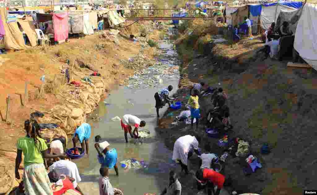 Displaced people wash their clothes in a drainage canal at Tomping camp, near Juba, Jan. 7, 2014.