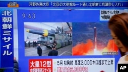 A woman walks past a TV screen broadcasting news of North Korea's missile launch, in Tokyo, Japan, Aug. 29, 2017. 