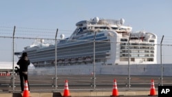 Seorang fotografer mengambil foto kapal pesiar Diamond Princess yang dikarantina di pelabuhan di Yokohama, dekat Tokyo, Jumat, 21 Februari 2020. (Foto: AP/Eugene Hoshiko)