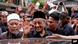 Malaysian Prime Minister Mahathir Mohamad, center, waves to crowds leaving National Mosque after performing Friday prayers in Kuala Lumpur, Malaysia, Friday, May 11, 2018.