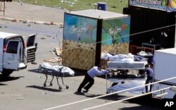 Investigators load bodies from the scene of a mass shooting at a music festival near the Mandalay Bay resort and casino on the Las Vegas Strip, Oct. 2, 2017, in Las Vegas.