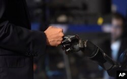 President Barack Obama fist-bumps with Nathan Copeland during a tour of innovation projects at the White House Frontiers Conference at University of Pittsburgh in Pittsburgh, Oct. 13, 2016.