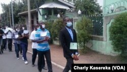 Les membres de la LUCHA lors d'une marche pacifique mardi15 mars à Goma Mains liées et bouche bandée en signe de solidarité avec leur camarades arretés à Kinshasa et à Goma, sur une route en plein centre ville de Goma