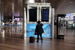 Seorang penumpang melihat monitor informasi di bandara internasional Ben Gurion, Israel, 25 Januari 2021, sebelum bandara tersebut ditutup untuk penerbangan internasional, yang berlaku mulai Senin tengah malam hingga akhir Januari.