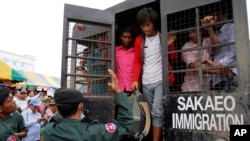Cambodian migrant workers get off from a Thai truck upon their arrival from Thailand at Cambodia-Thai international border gate in Poipet, Cambodia, Tuesday, June 17, 2014.