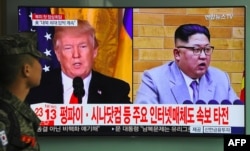 FILE - A South Korean soldier walks past a television screen showing images of U.S. President Donald Trump and North Korean leader Kim Jong Un at a railway station in Seoul, South Korea, March 9, 2018.