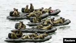 Japan Self-Defense Force (JSDF) soldiers ride rubber boats on the sea approach to Eniyabanare Island during a military drills, off Setouchi town on the southern Japanese island of Amami Oshima, Kagoshima prefecture, in this photo taken by Kyodo May 22, 20