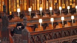 FILE - Britain's Queen Elizabeth II sits alone in St. George's Chapel during the funeral of Prince Philip, her husband of 73 years, at Windsor Castle, Windsor, England, April 17, 2021.