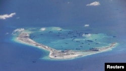 FILE - Chinese dredging vessels are purportedly seen in the waters around Mischief Reef in the disputed Spratly Islands in the South China Sea, in an image taken by a P-8A Poseidon surveillance aircraft and provided by the U.S. Navy, May 21, 2015.