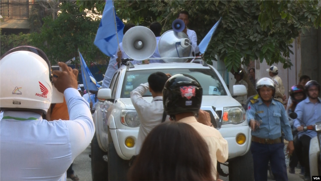Traffic police officer facilitate the traffic for the demonstrators during the protest against CNRP's acting president, Kem Sokha. (Pin Sisovann/VOA Khmer)