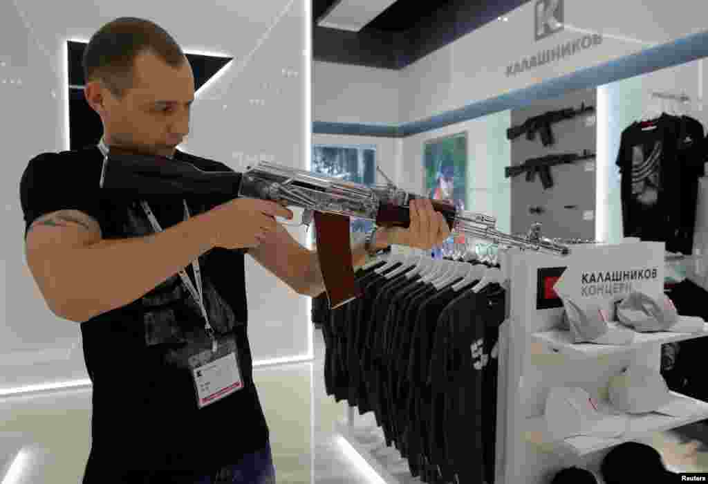 A salesperson demonstrates a model AK-47 assault rifle at the newly opened Gunmaker Kalashnikov souvenir store in Moscow's Sheremetyevo airport, Russia, Aug. 22, 2016.