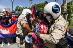 FILE - Local security personnel guards confiscate a loudspeaker from a protester during a protest to mark the 29th annniversary of the Paris Peace Accord in front of the US embassy in Phnom Penh on October 23, 2020. (AFP)