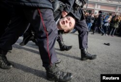 Law enforcement officers detain an opposition supporter during a rally in Moscow, Russia, March 26, 2017.