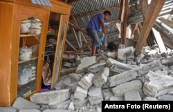 A villager walks through the ruins of a collapsed house during a search for the equipment of Malaysian tourists who died during the earthquake at the Sembalun Selong village in Lombok Timur, Indonesia, July 29, 2018.