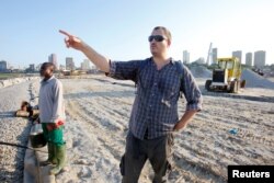 American conservation biologist and crocodile expert Matt Shirley stands near a section of the lagoon in Abidjan where a big high-end residential and commercial development is under construction, Ivory Coast, July 12, 2017.